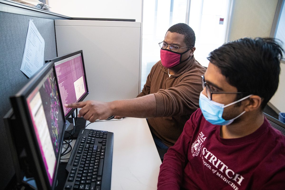 Loyola University Chicago Professor Whelton Miller works with a graduate student on 3D-modeling of molecules. (Photo by: Lukas Keapproth)