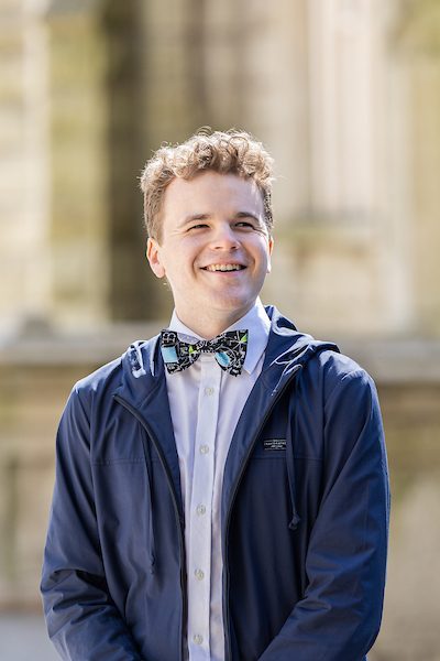 A portrait of Aidan Doyle smiling outdoors on Loyola University Chicago's campus