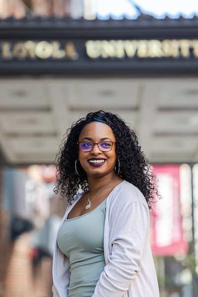 A portrait of Janese Nolan smiling outdoors on Loyola University Chicago's campus