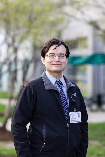 A portrait of Cesar Montelongo Hernandez smiling outdoors on Loyola University Chicago's campus