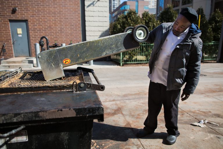Cook empties used cooking grease into a receptacle that is then collected and sent to the Searle Biodiesel Lab to be processed into biodiesel fuel.
