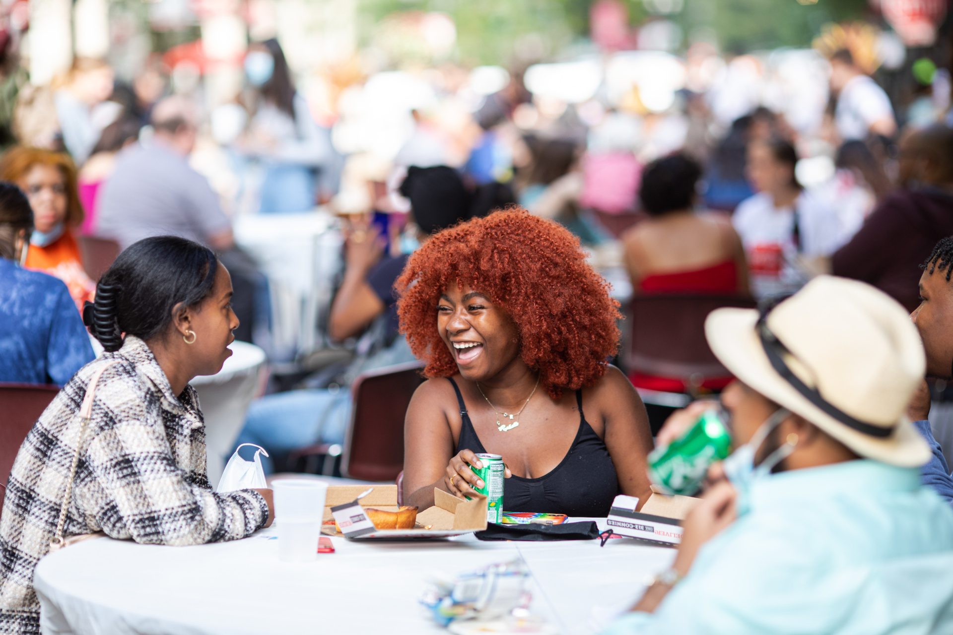 Students laughing while sitting at a table at the Water Tower Campus Block Party.