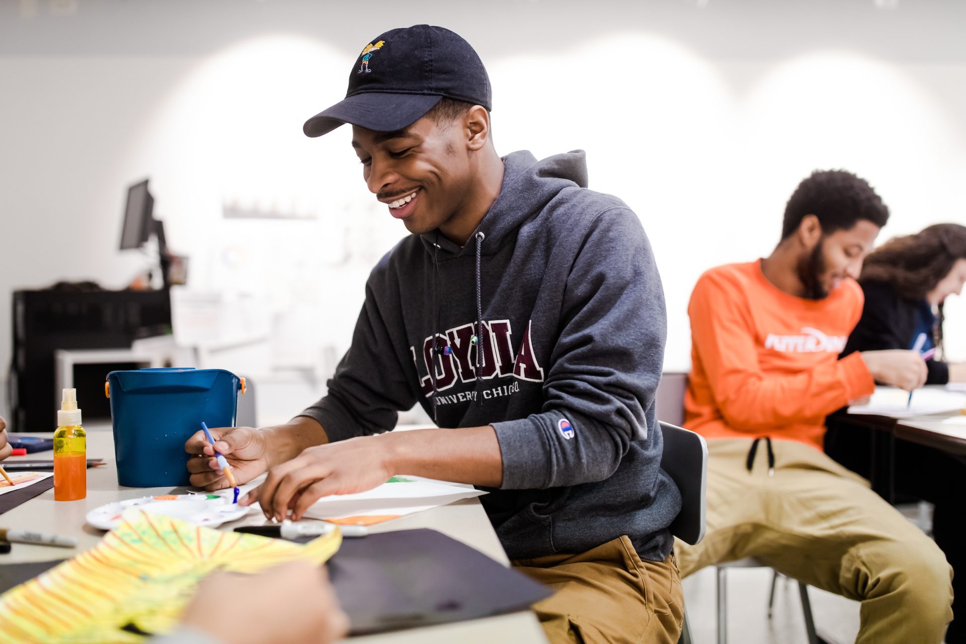 Arrupe College student working with paint on an art project in classroom